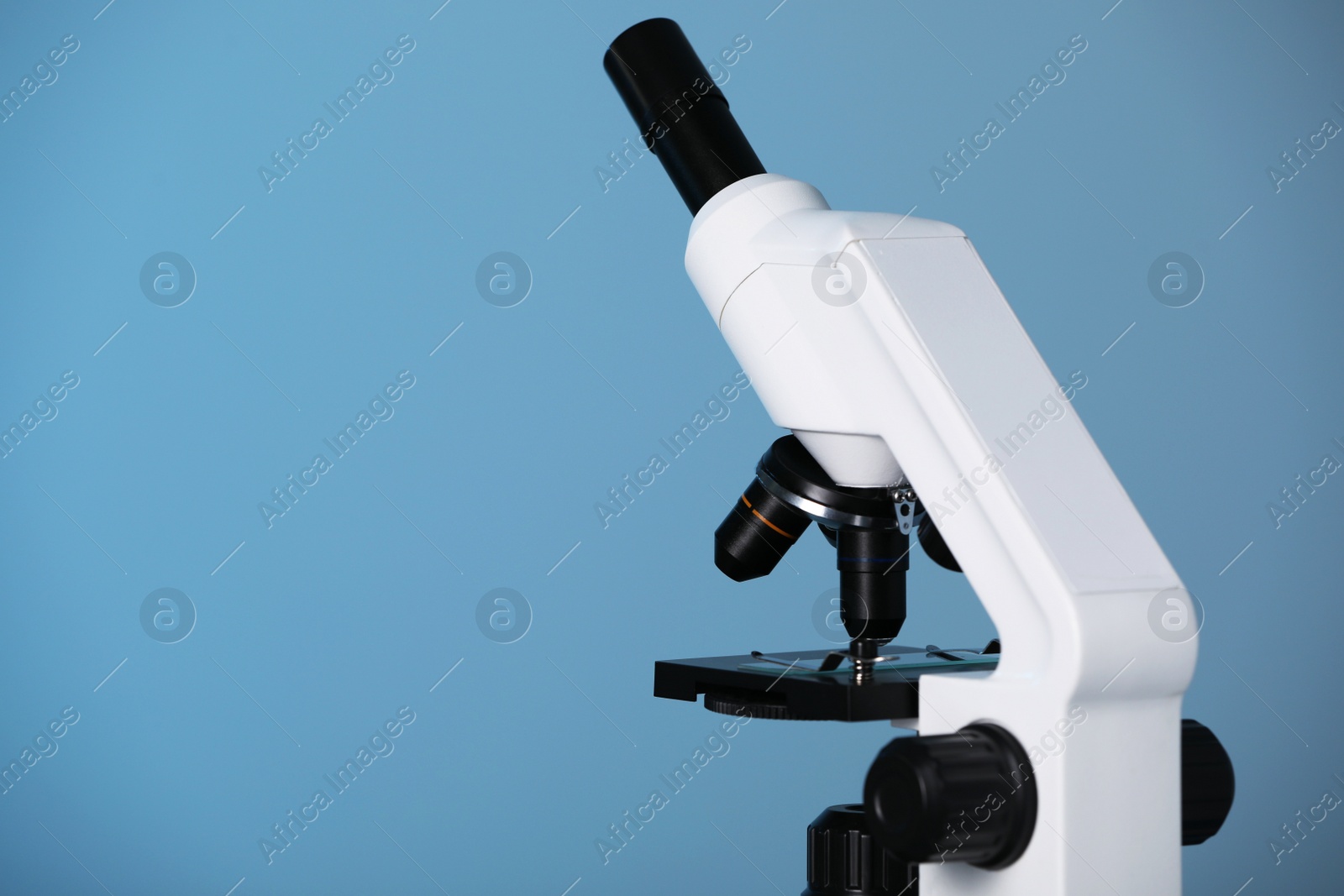 Photo of Modern microscope on blue background. Space for text