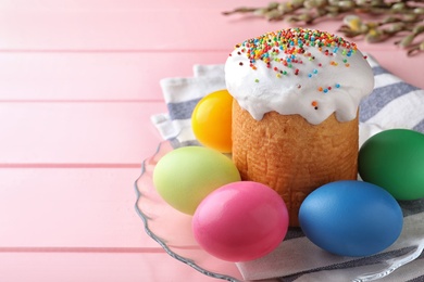 Traditional Easter cake, colorful eggs and willow branches on pink table, closeup. Space for text