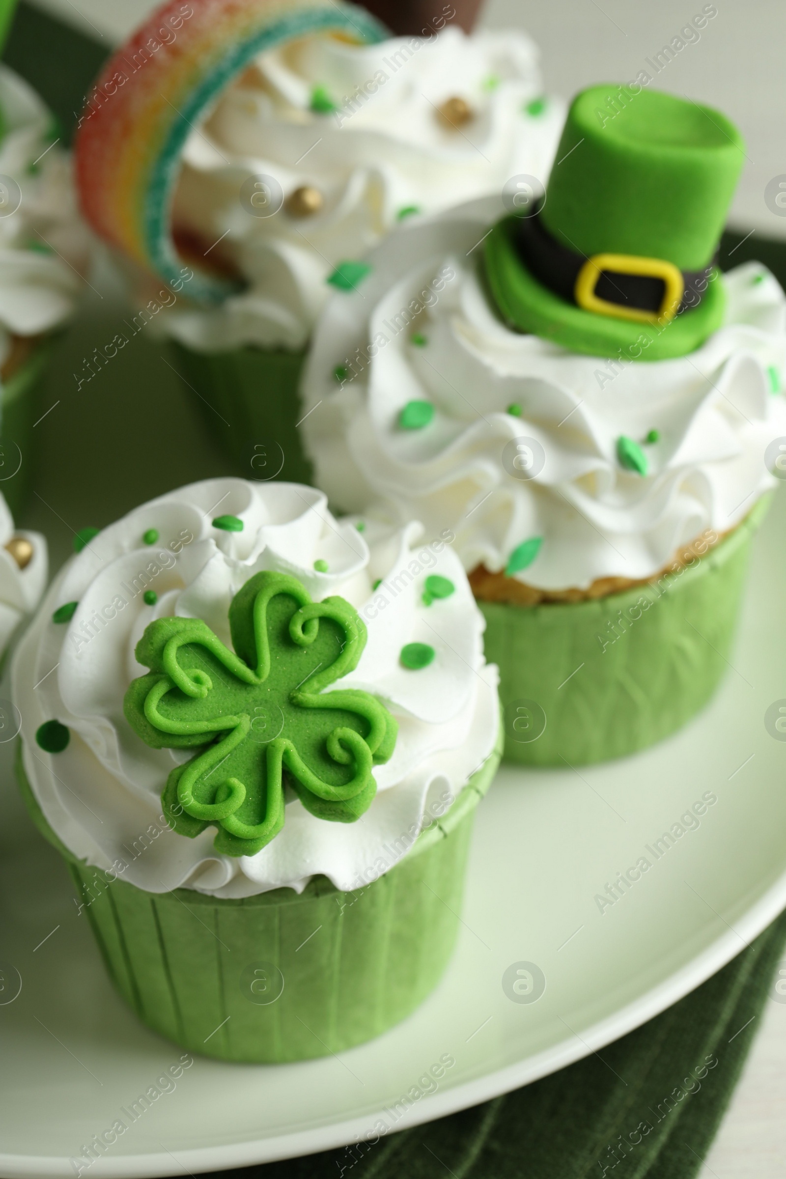 Photo of St. Patrick's day party. Tasty festively decorated cupcakes on table, closeup