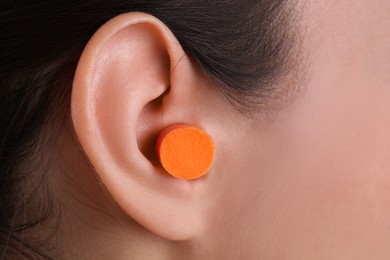 Photo of Young woman with  foam ear plug, closeup view