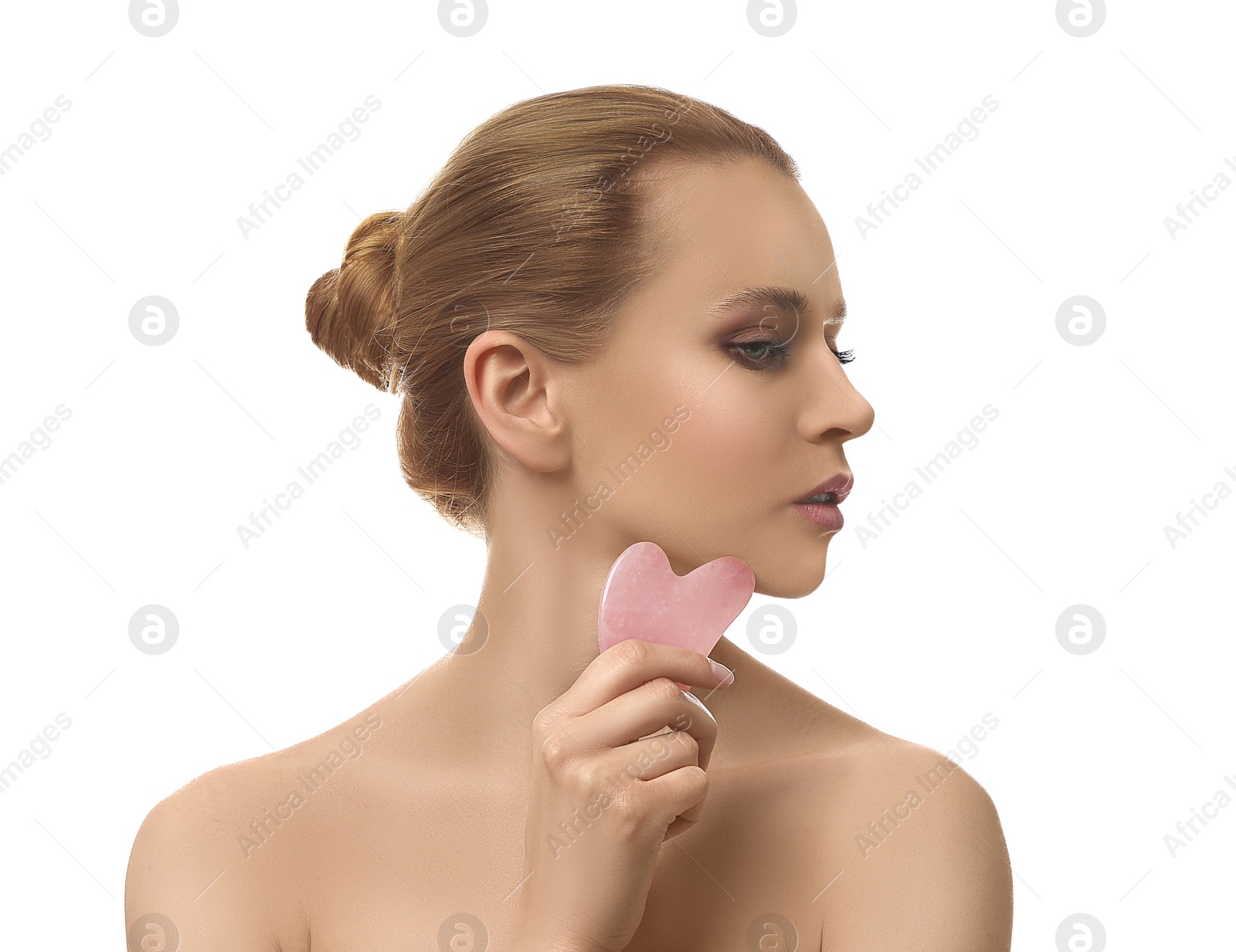 Photo of Beautiful young woman doing facial massage with gua sha tool on white background