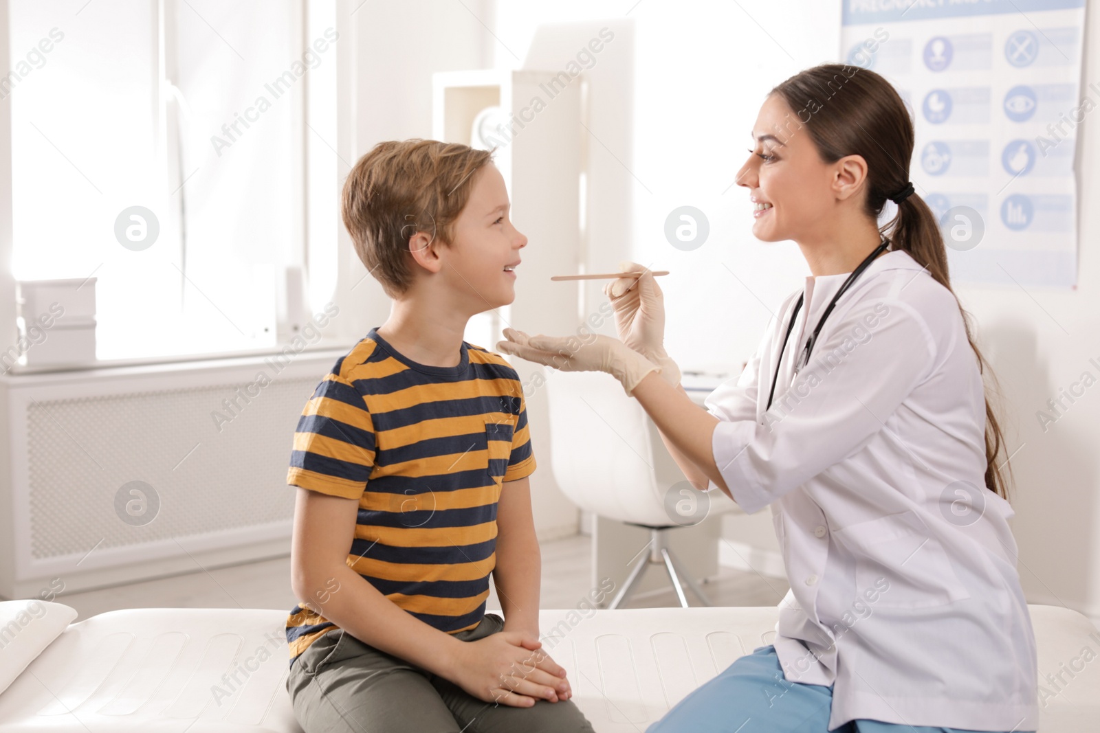 Photo of Doctor examining adorable child in hospital office