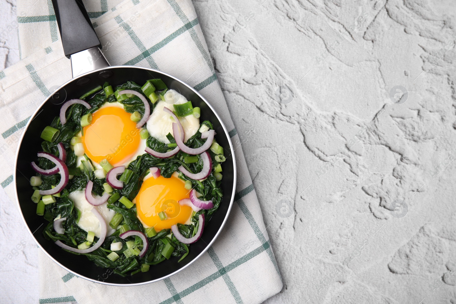 Photo of Tasty green Shakshouka served on white textured table, top view. Space for text