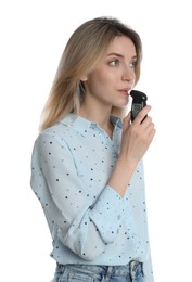 Young woman blowing into breathalyzer on white background