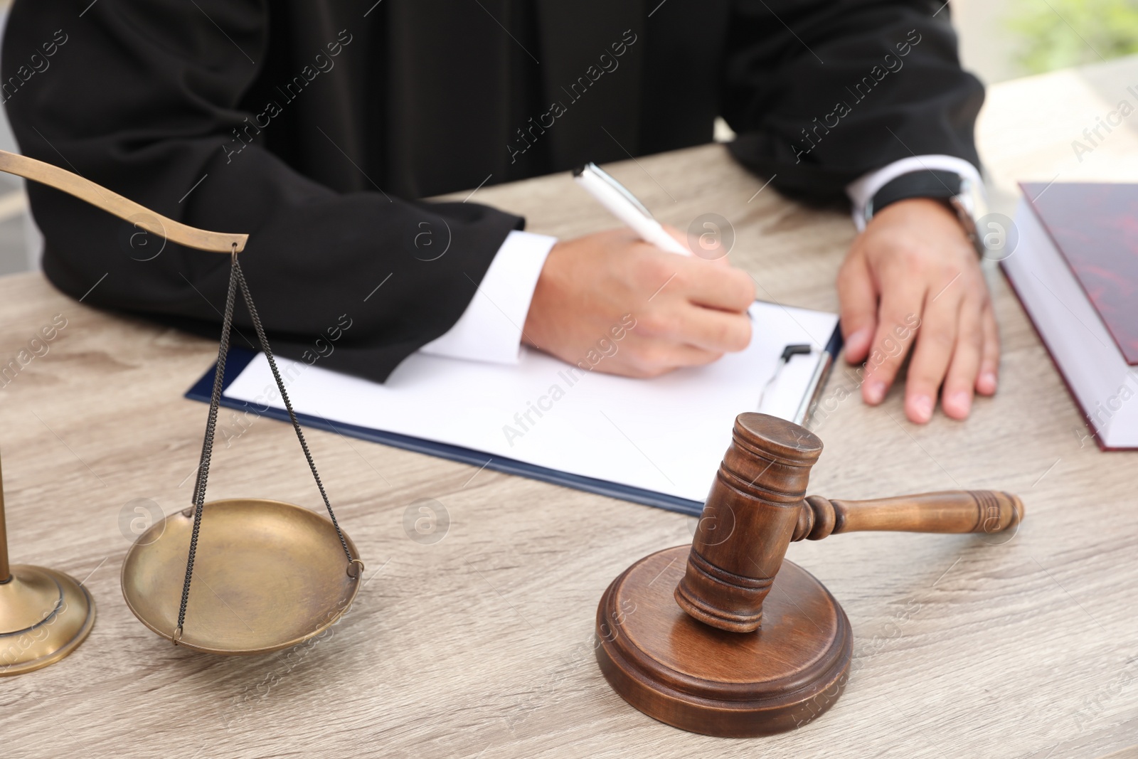 Photo of Judge working at wooden table indoors, closeup. Criminal law