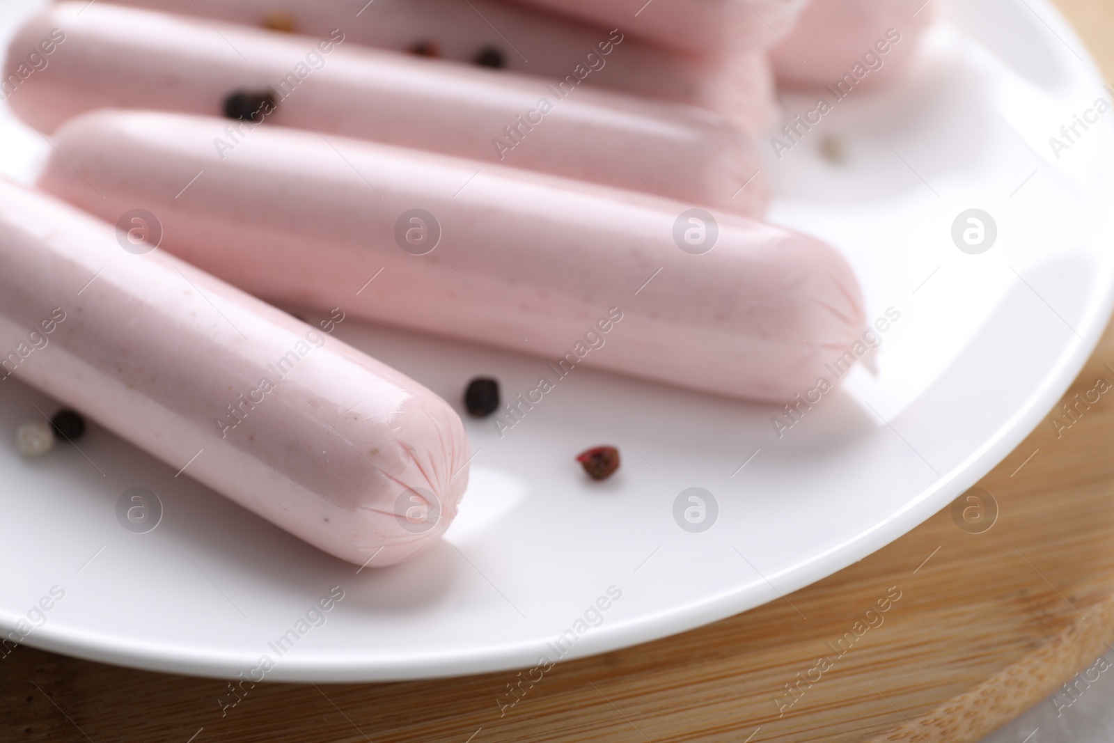 Photo of Vegan sausages with spices on wooden board, closeup