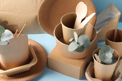 Eco friendly food packaging. Paper containers, tableware and eucalyptus branches on white table