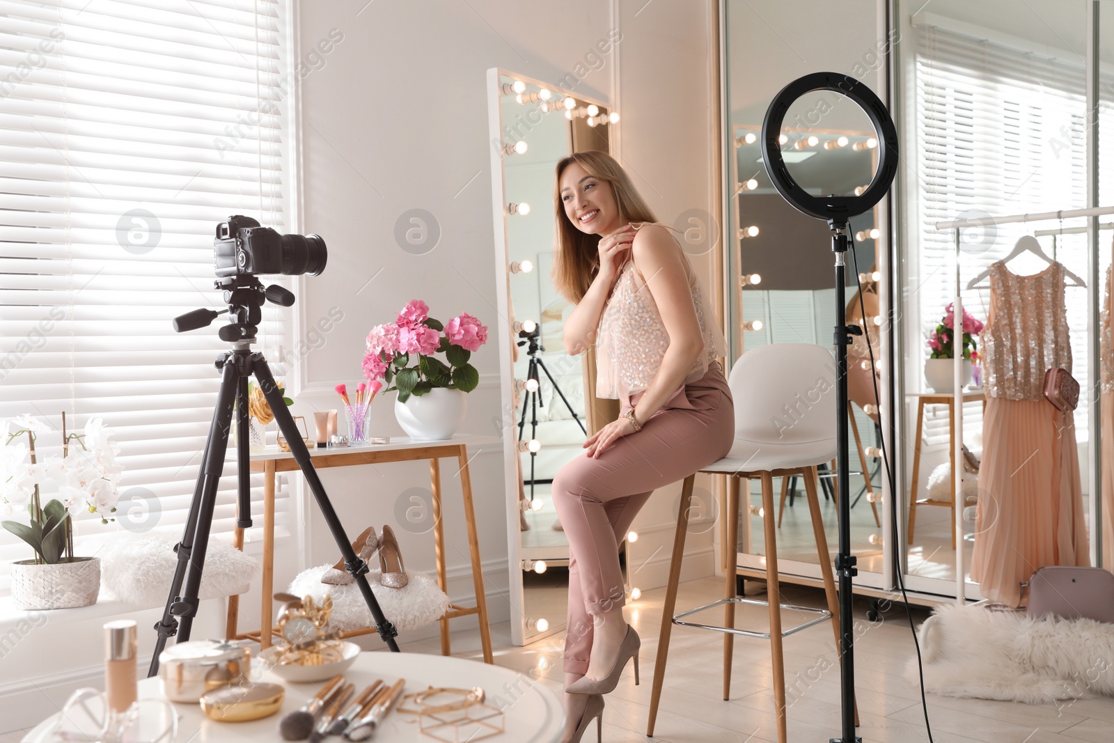 Photo of Blogger recording video in dressing room at home. Using ring lamp and camera