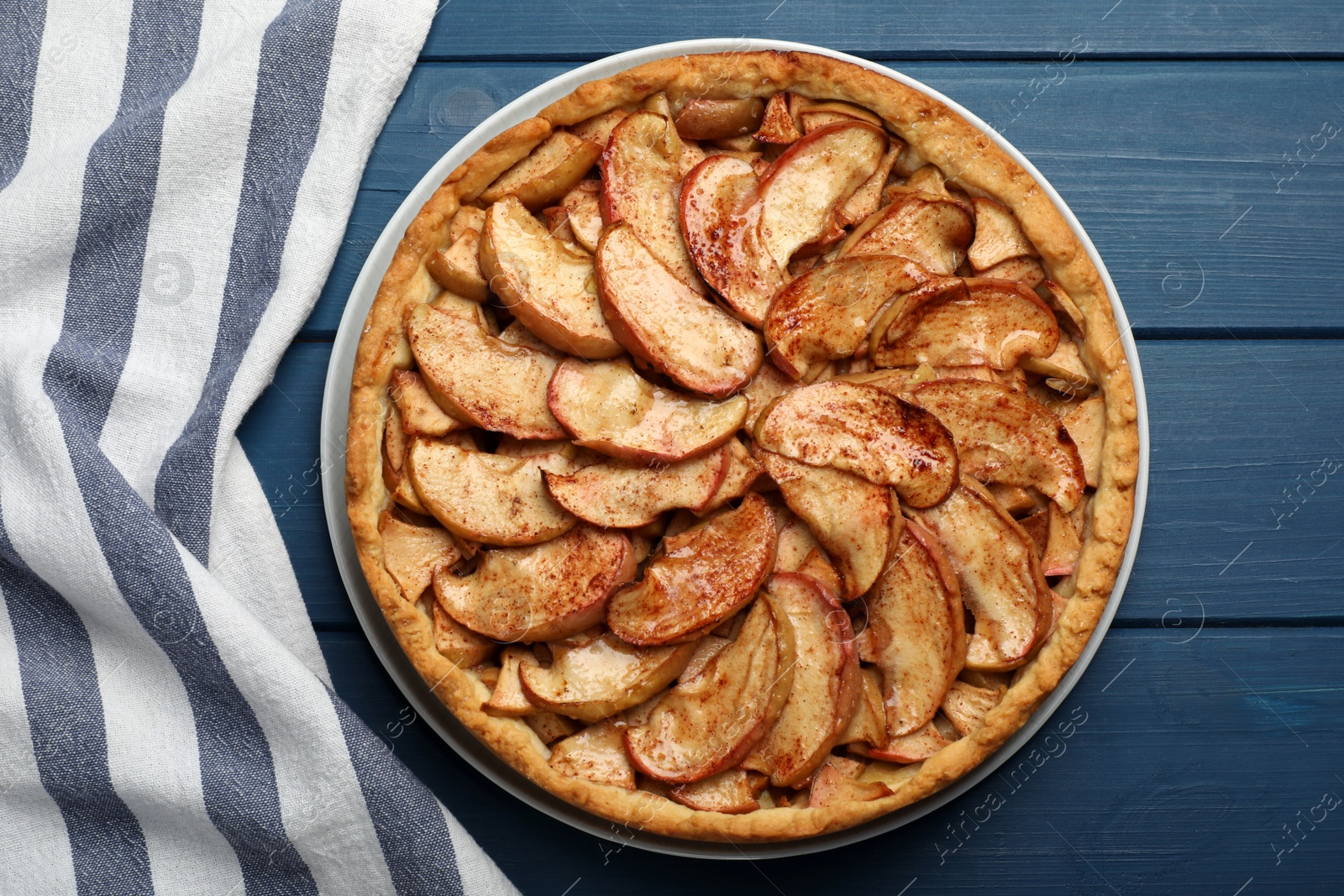 Photo of Delicious apple pie on blue wooden table, top view