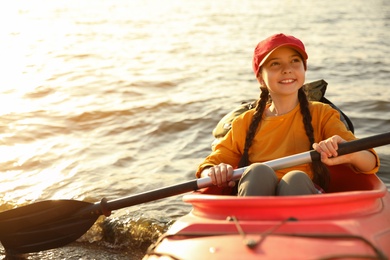 Photo of Happy girl kayaking on river. Summer camp activity