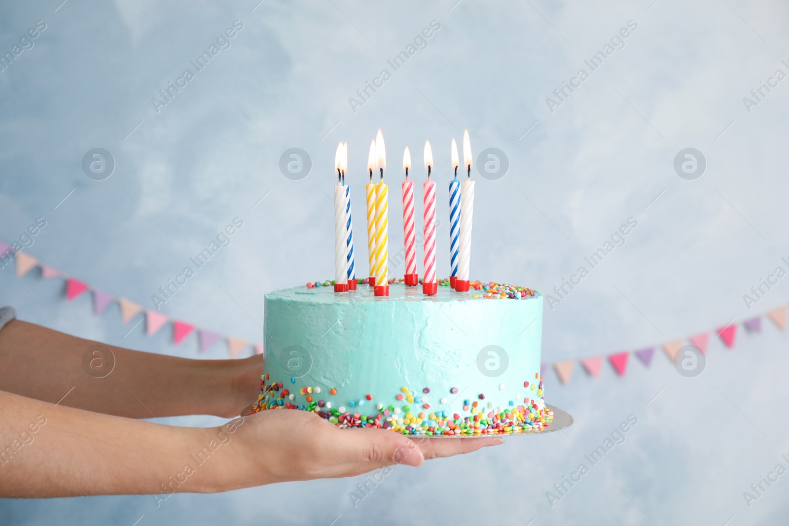 Photo of Woman holding fresh delicious birthday cake with candles on color background