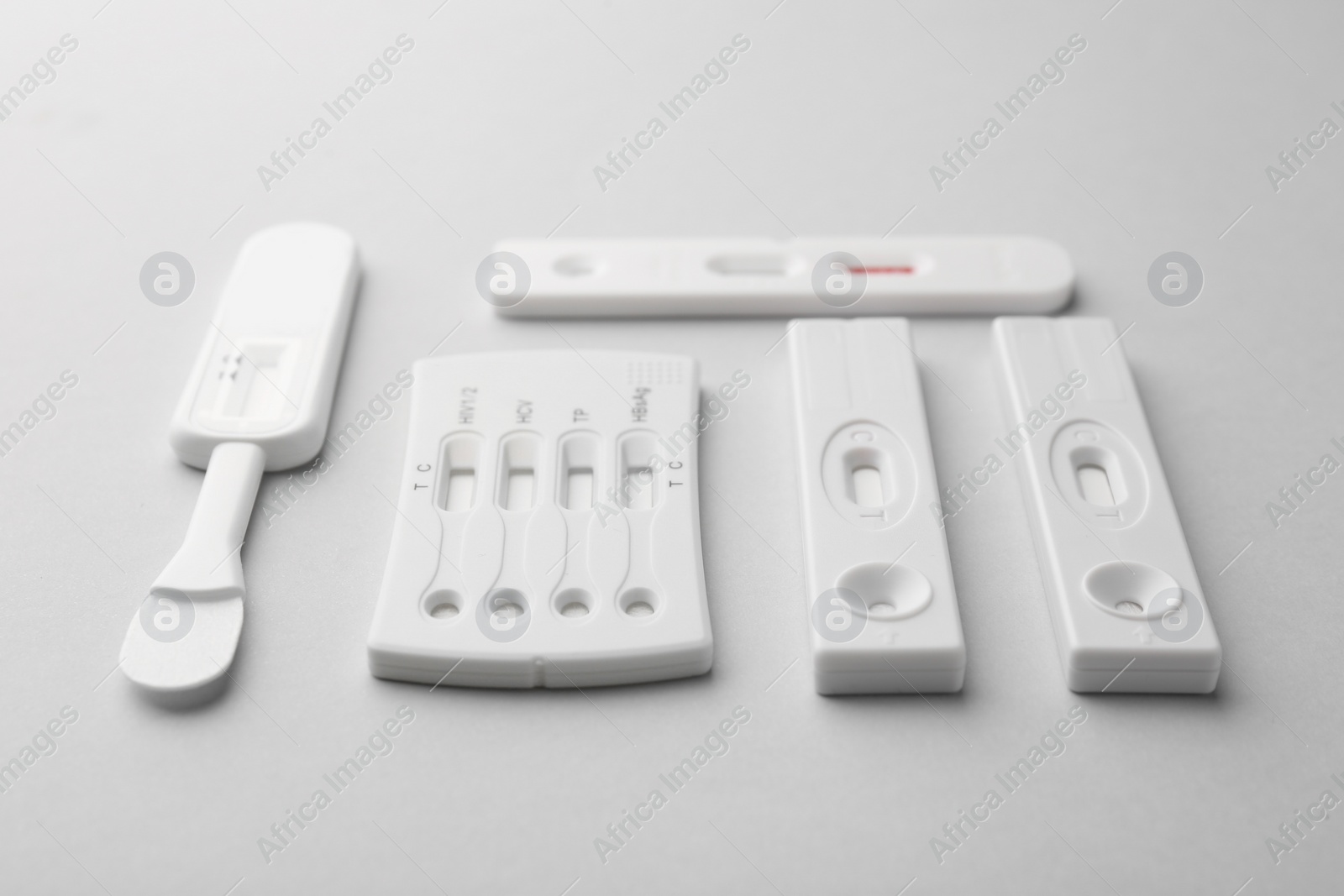 Photo of Different disposable express tests on light grey background