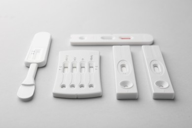 Photo of Different disposable express tests on light grey background