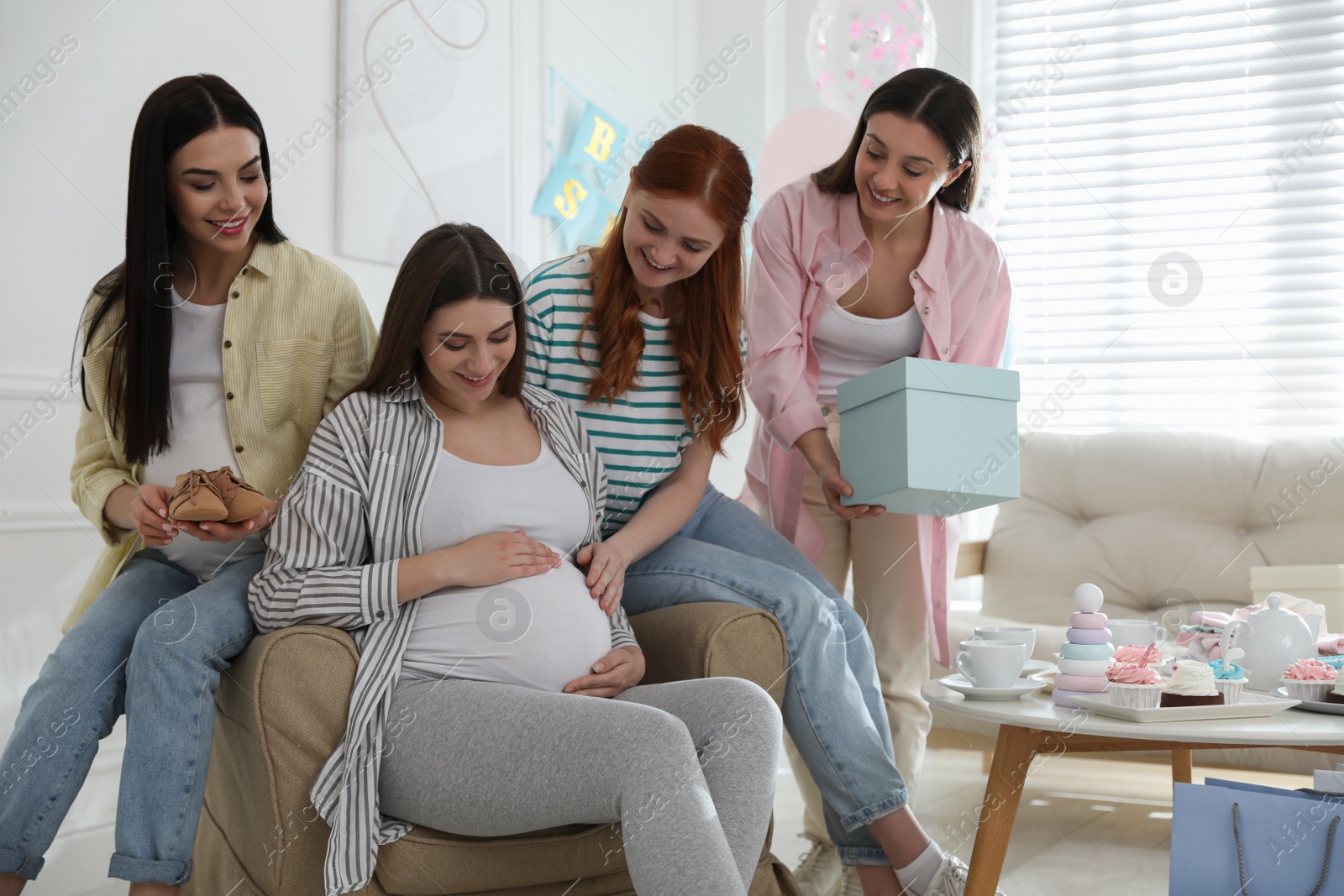 Photo of Happy pregnant woman spending time with friends at baby shower party