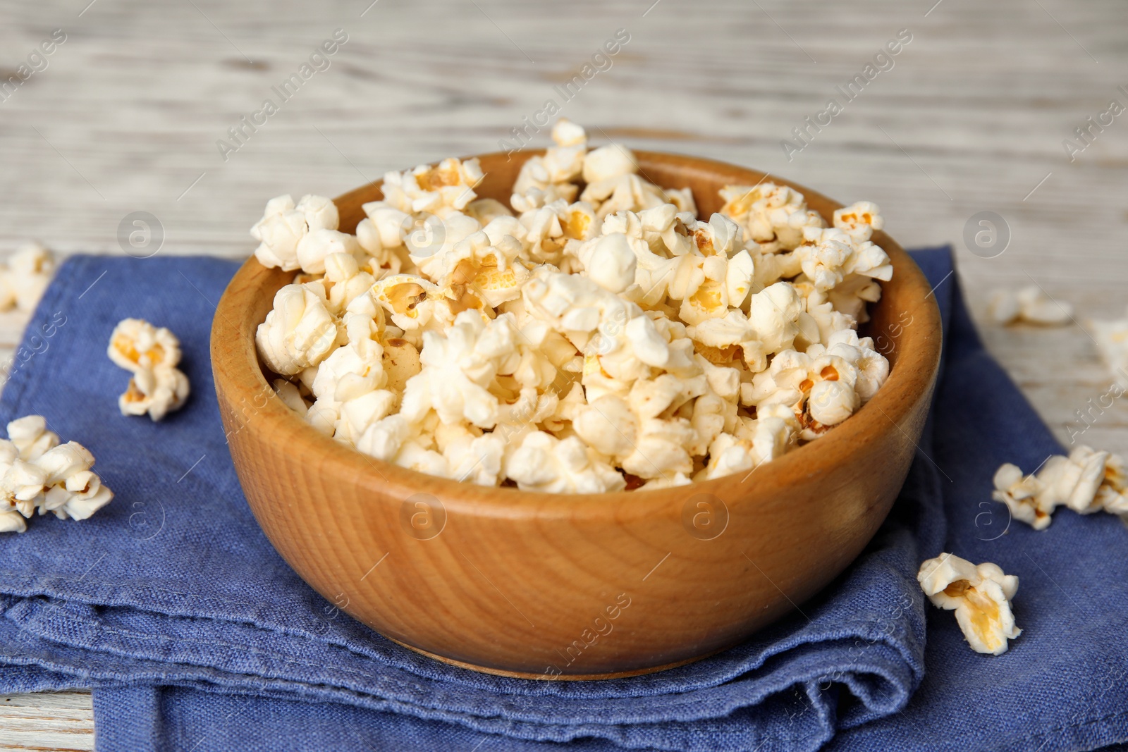 Photo of Tasty pop corn on white wooden table, closeup