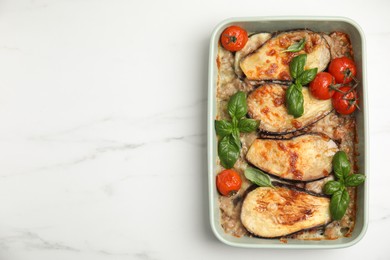 Photo of Delicious eggplant lasagna in baking dish on white marble table, top view. Space for text