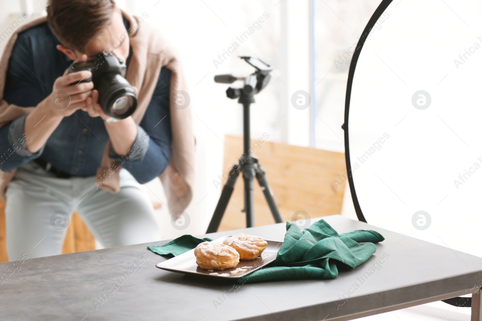 Photo of Young man taking picture of food in photo studio