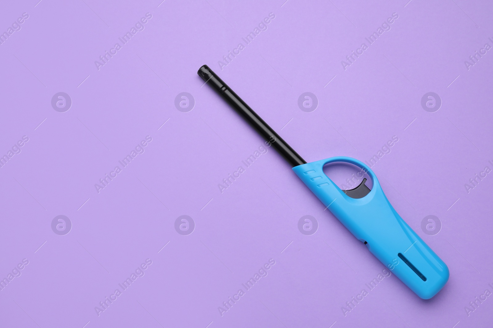 Photo of One gas lighter on violet background, top view. Space for text