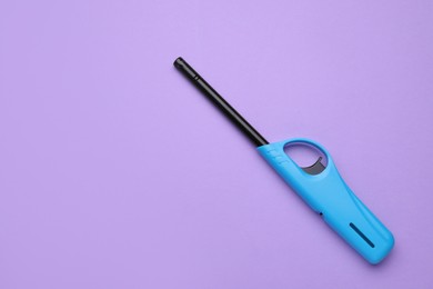 Photo of One gas lighter on violet background, top view. Space for text