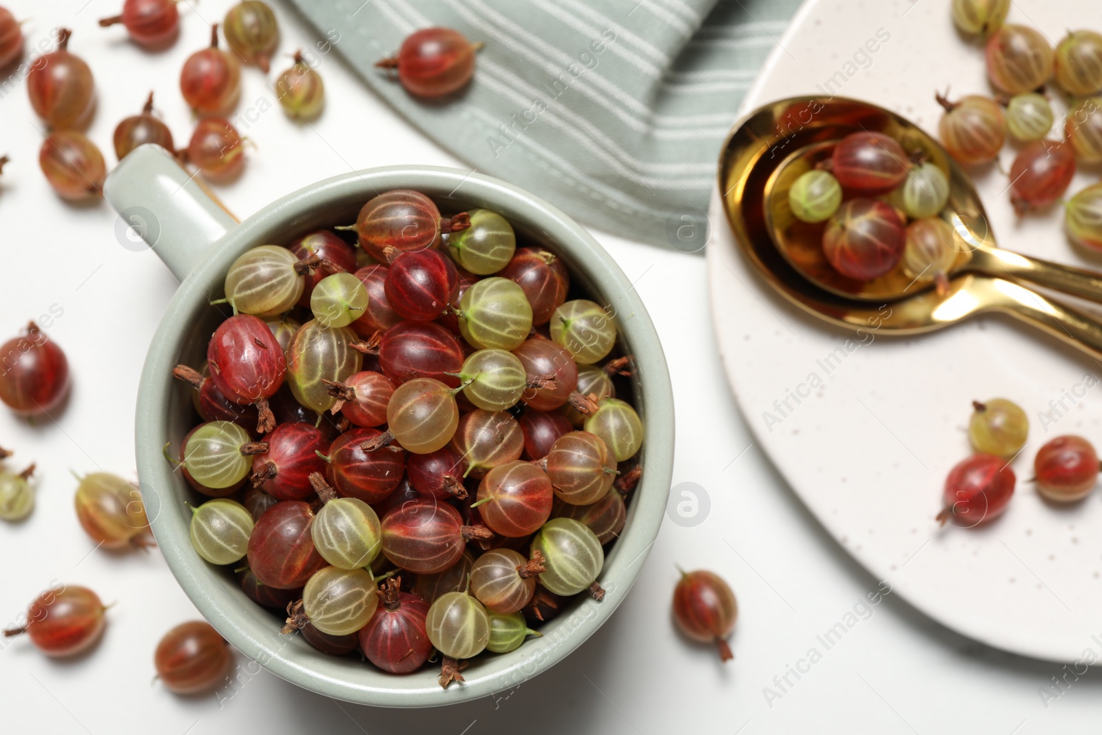 Photo of Fresh ripe gooseberries on white table, flat lay