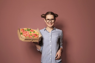 Photo of Attractive young woman with delicious pizza on color background