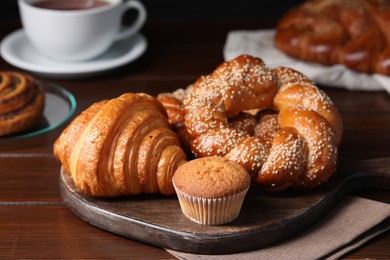 Photo of Different tasty freshly baked pastries on wooden table, closeup