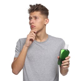 Photo of Thoughtful young man with mouthwash on white background