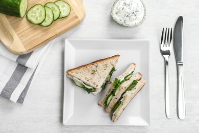 Photo of Flat lay composition with plate of cucumber sandwiches on table