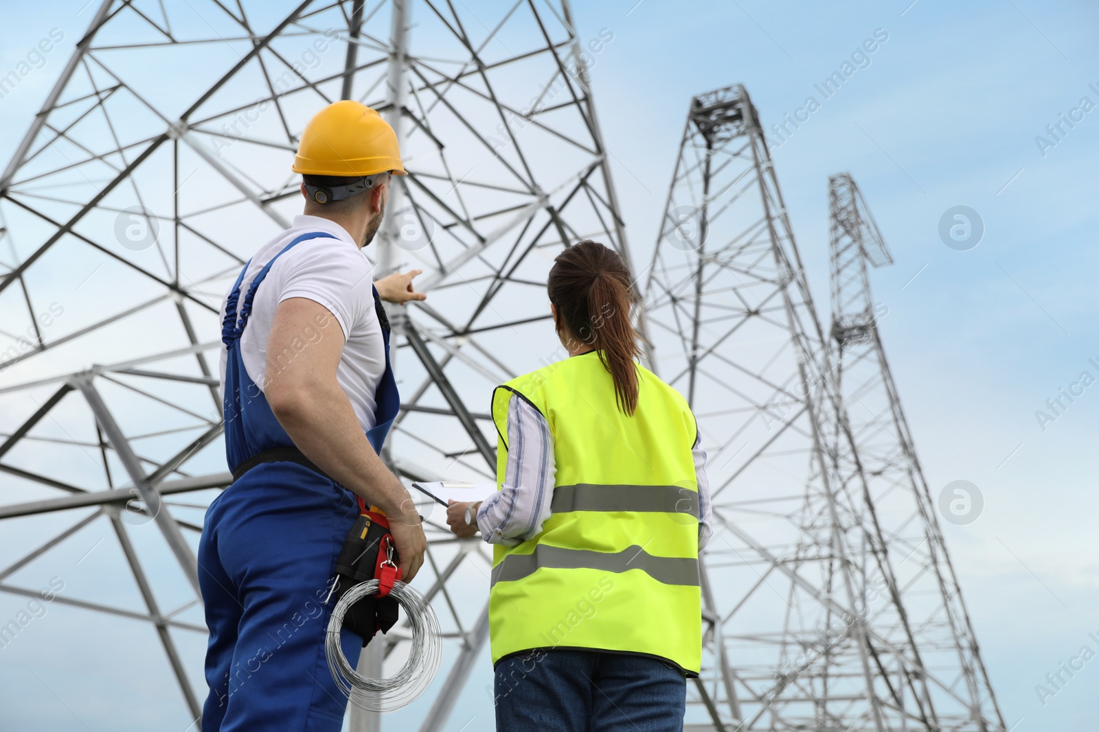 Photo of Professional engineers working on installation of electrical substation outdoors