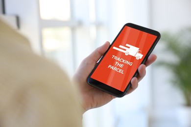 Image of Woman tracking parcel via smartphone indoors, closeup
