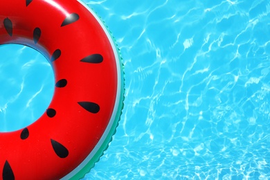 Photo of Inflatable ring floating in swimming pool on sunny day, top view with space for text