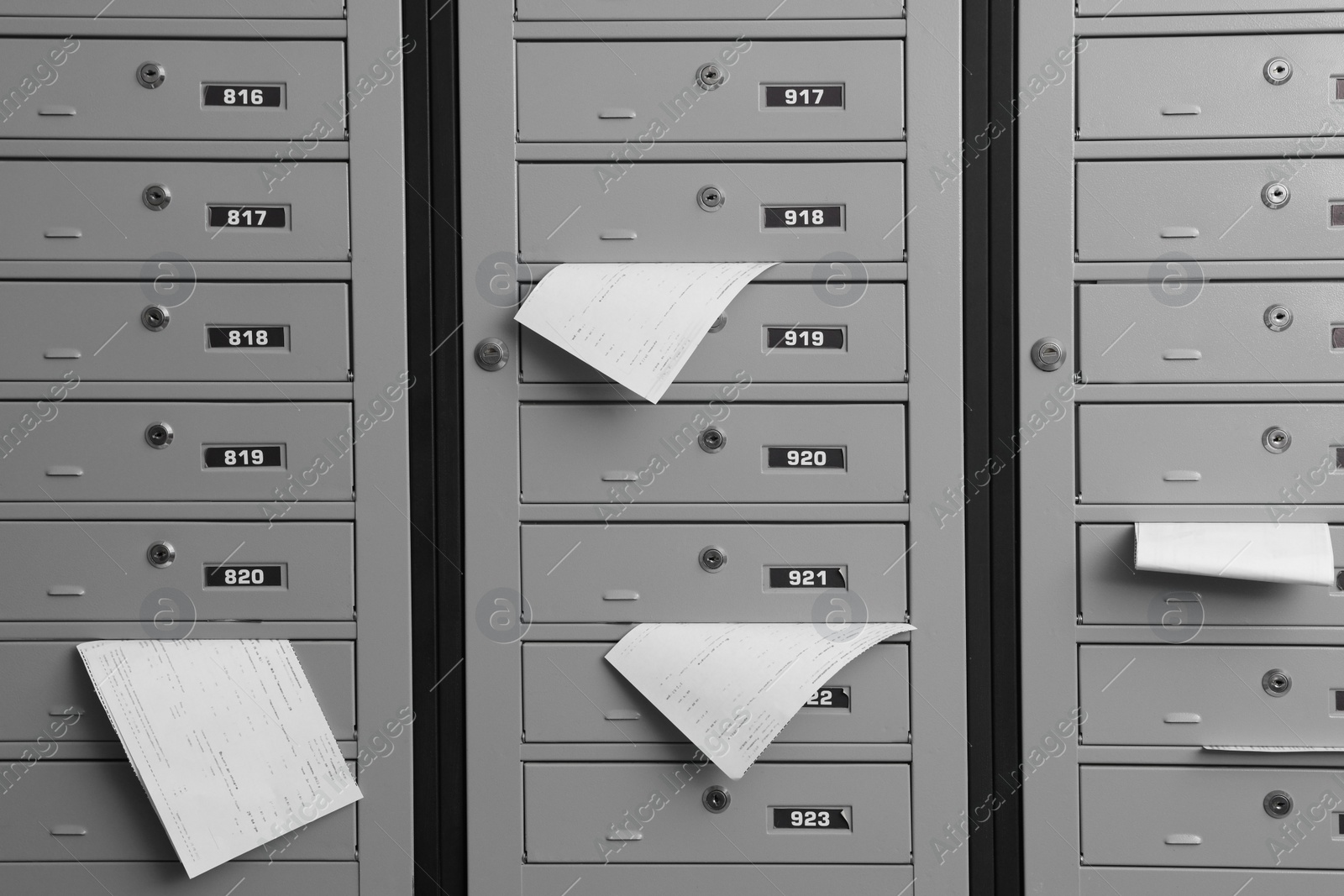 Photo of Closed grey metal mailboxes with receipts indoors