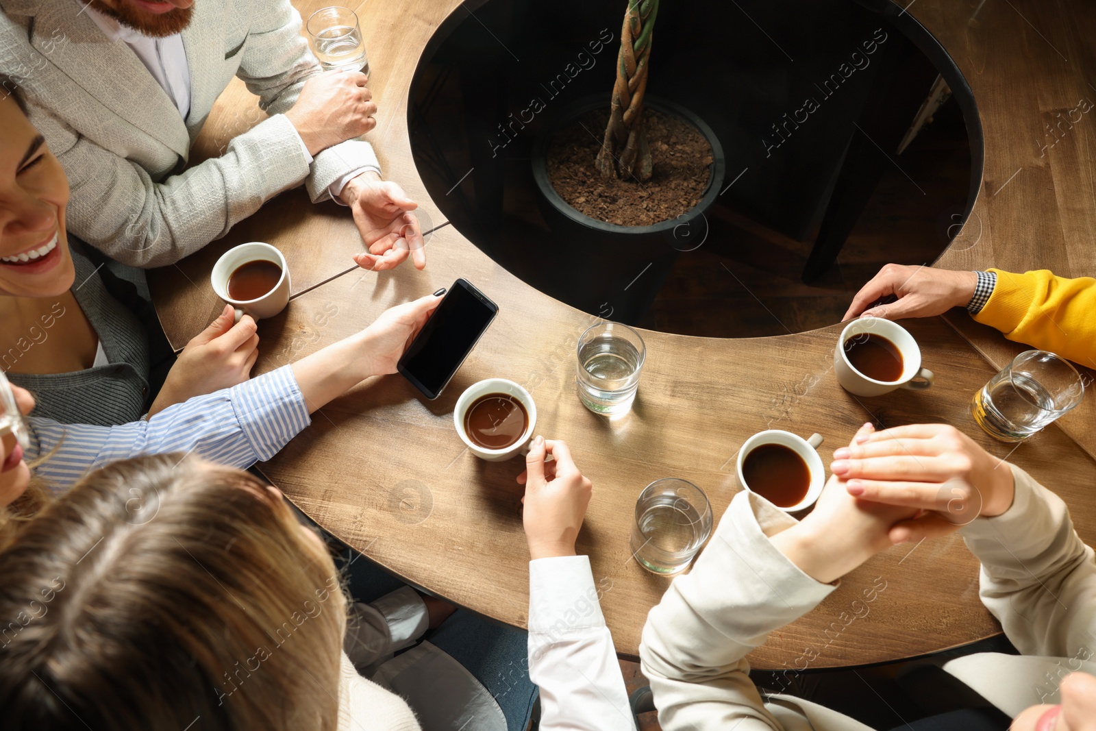 Photo of Friends with coffee spending time together in cafe, above view