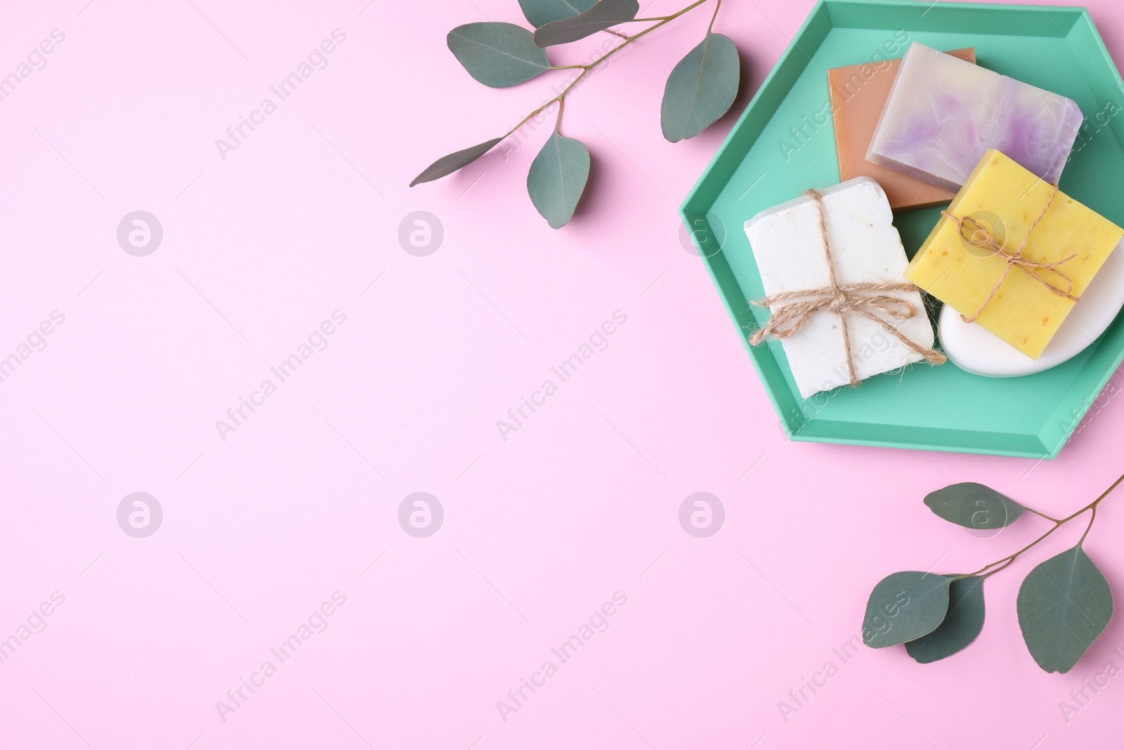 Photo of Flat lay composition with soap bars and green branches on color background. Space for text
