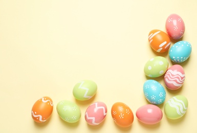 Photo of Flat lay composition of painted Easter eggs on color background, space for text