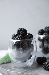 Photo of Delicious fresh ripe blackberries in glass on table