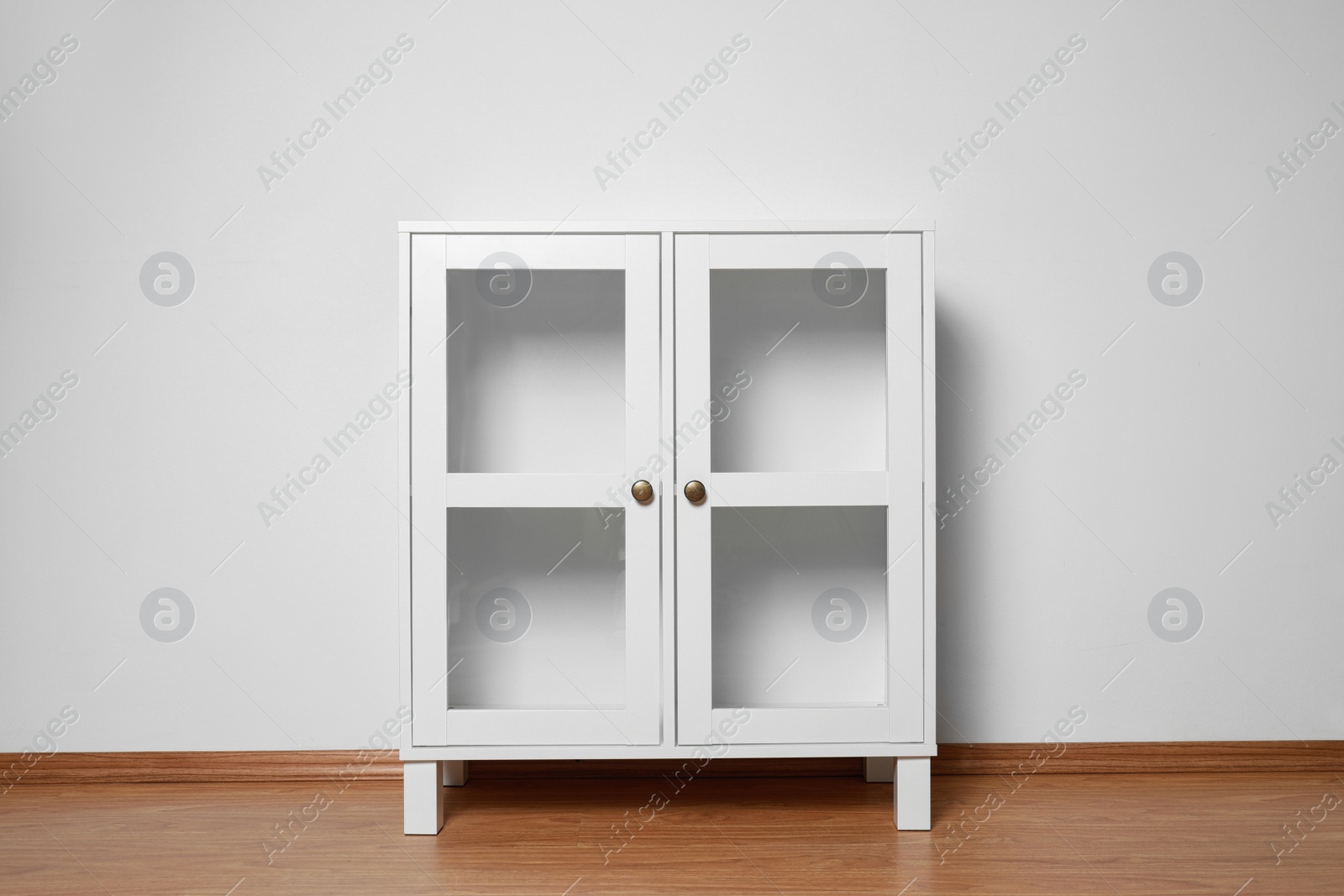 Photo of Empty wooden cabinet near white wall. Stylish home furniture