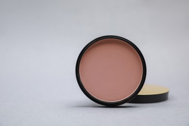 Photo of Open face powder on light grey background. Space for text