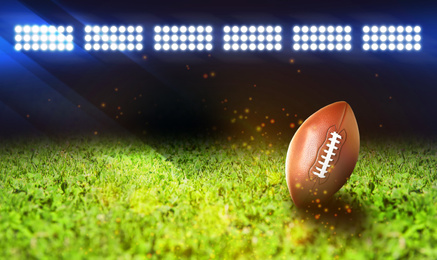 Image of Leather American ball on green football field, space for text. Banner design  