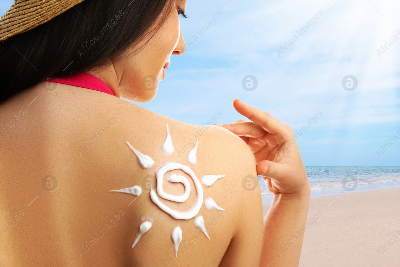 Image of Young woman with sun protection cream on her back at beach, closeup