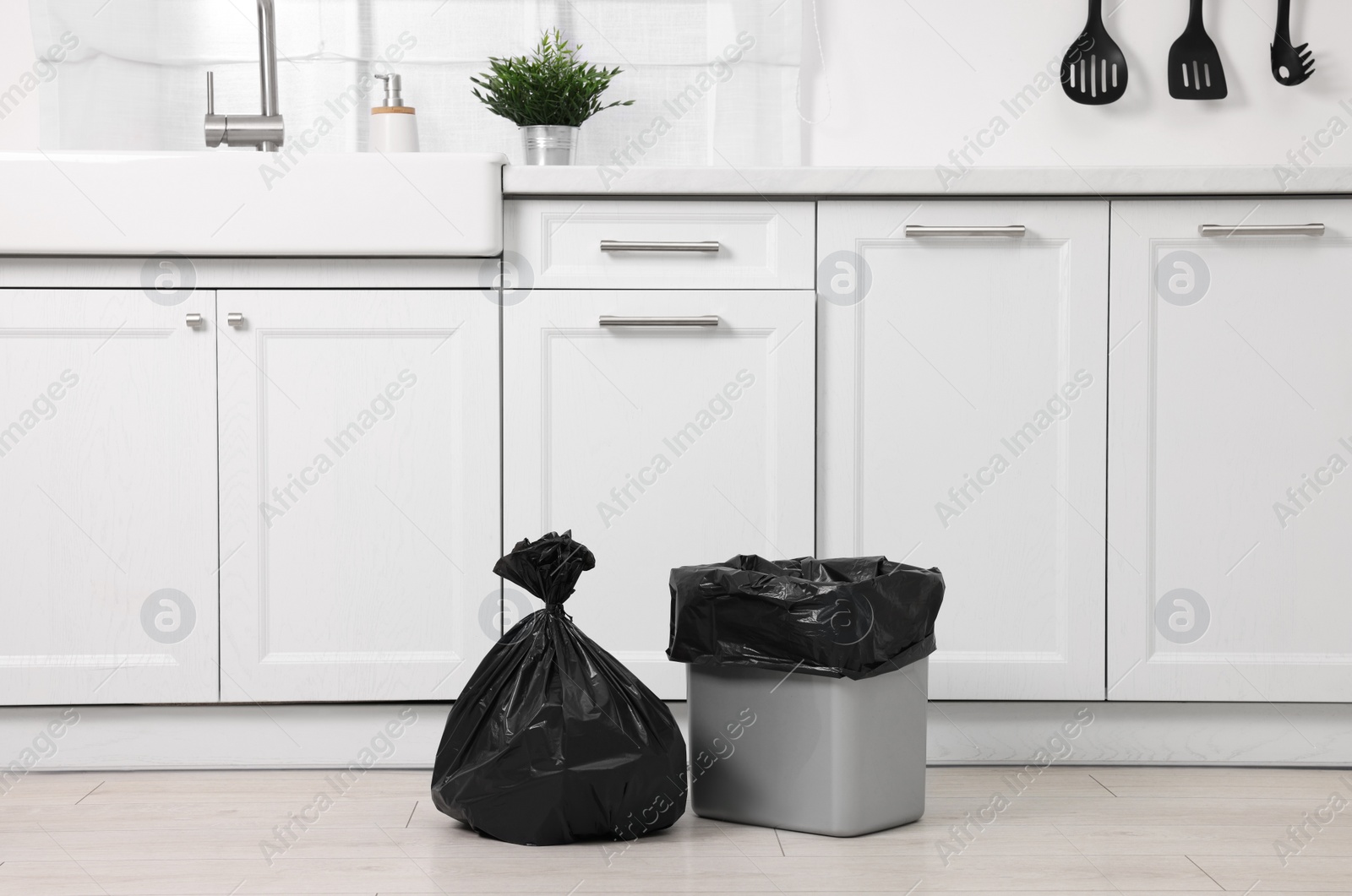 Photo of Plastic garbage bag and trash can in kitchen