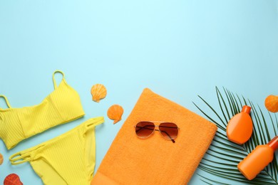 Flat lay composition with different beach objects on light blue background, space for text