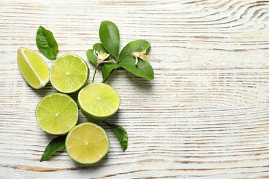 Composition with fresh ripe limes on wooden background, top view