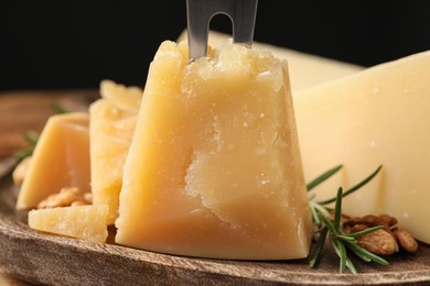 Delicious parmesan cheese on wooden board, closeup