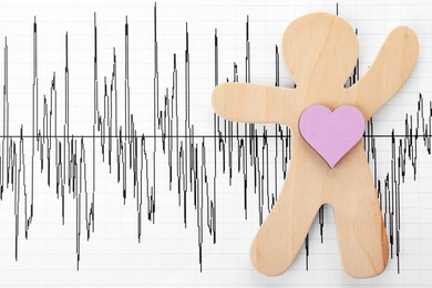 Photo of Human figure with heart on cardiogram, top view. Space for text