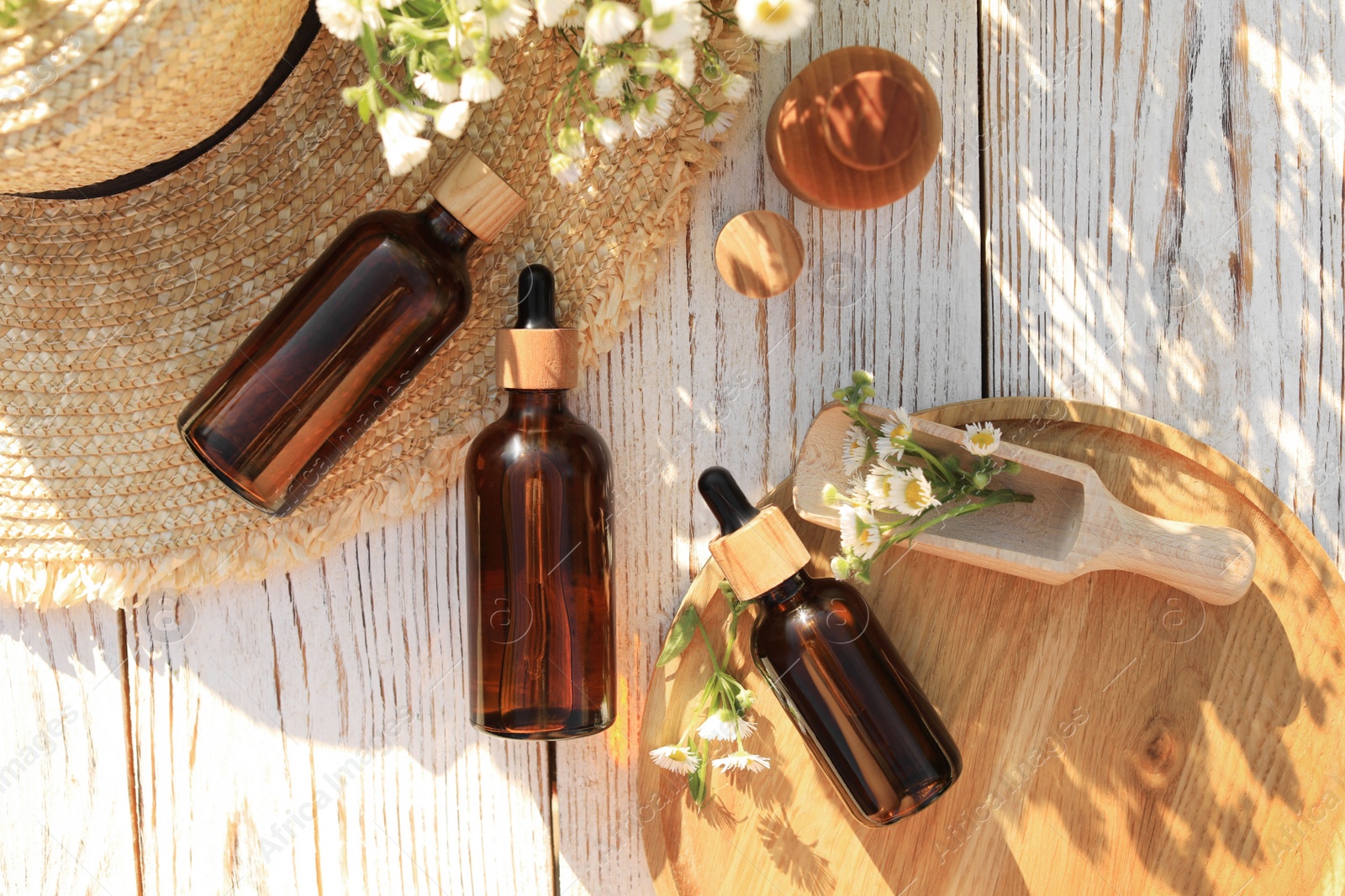 Photo of Flat lay composition with chamomile essential oil and flowers on white wooden table