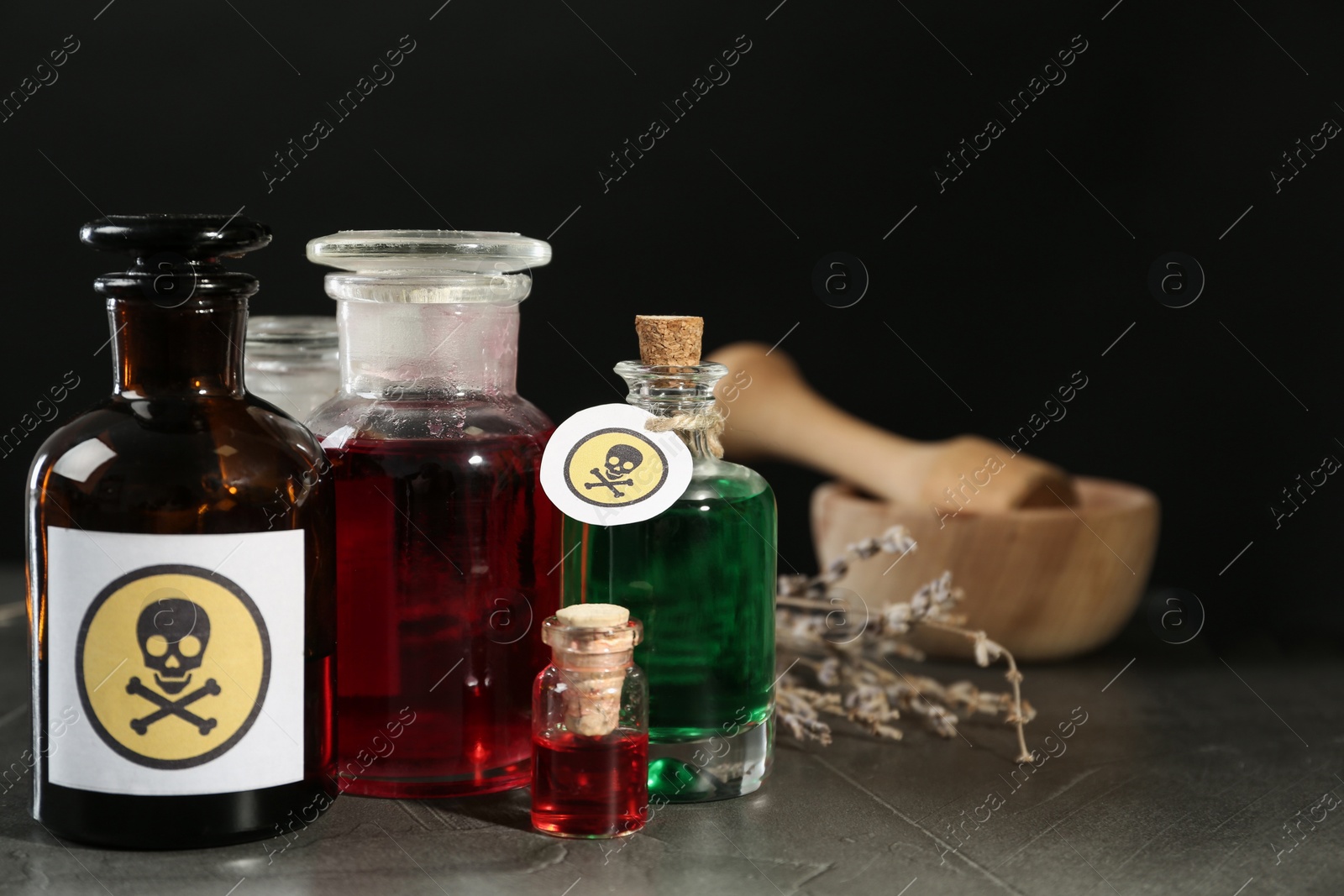 Photo of Bottles with poison on grey table. Space for text