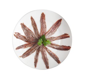 Plate with anchovy fillets and parsley on white background, top view