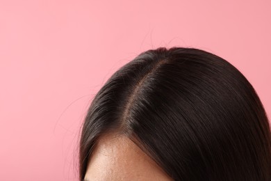 Woman with healthy hair on pink background, closeup. Space for text