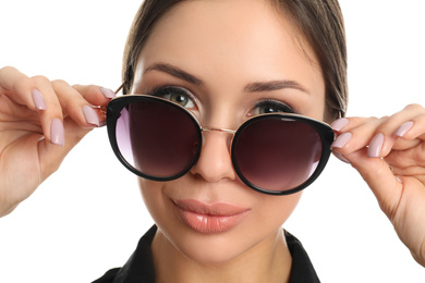 Beautiful young woman wearing sunglasses on white background, closeup